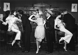 Image of Audrey Hepburn and Art Buchwald, with Simone D'Aillencourt, Frederick Eberstadt, Barbara Mullen, and Dr. Reginald Kernan, evening dresses by Balmain, Dior, and Patou, Maxim's, Paris, August 1959